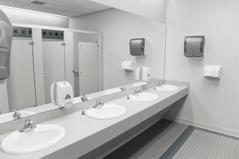A commercial bathroom with white sinks