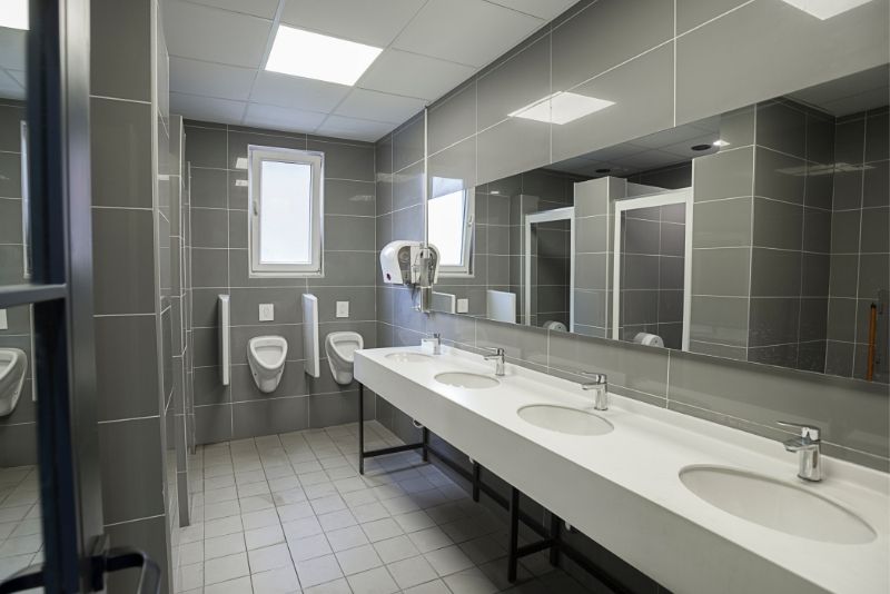 A commercial bathroom with a separate urinal