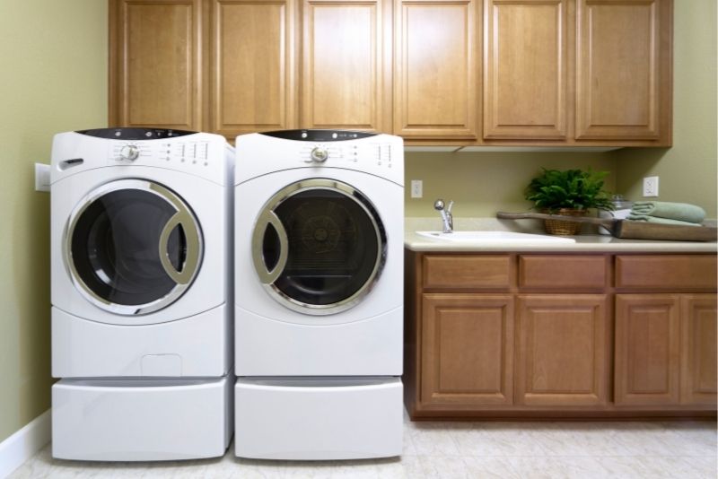 A laundry room with wooden cabinets